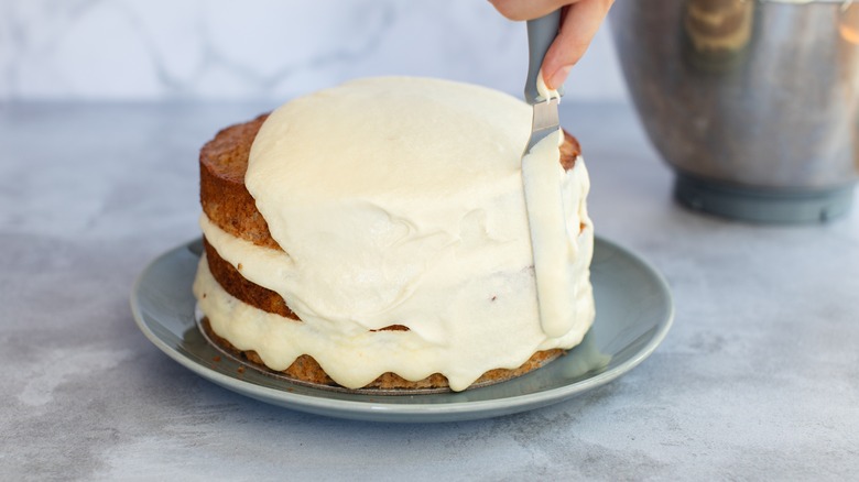 Person icing a cake