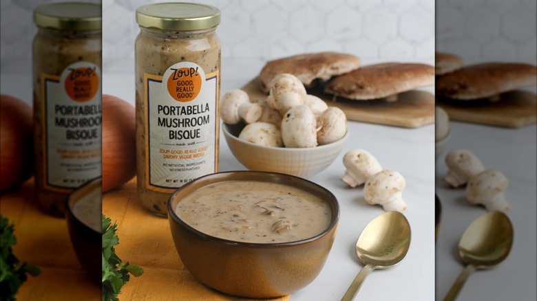 A bowl of Zoup! Cream of Mushroom soup sitting next to its jar.