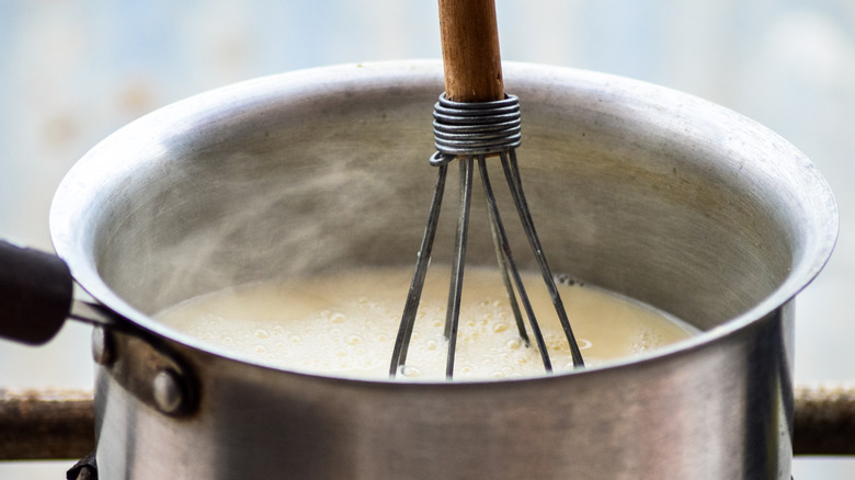 milk in pot with whisk