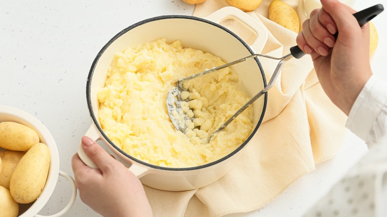 Mashing potatoes in a pan