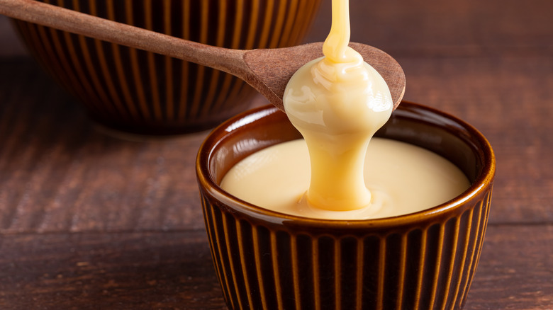 Condensed milk in bowl and spoon