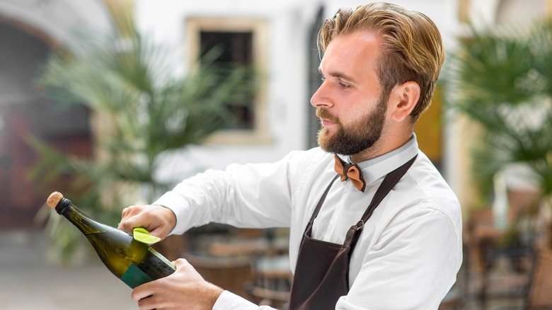 Bartender preparing to saber champagne