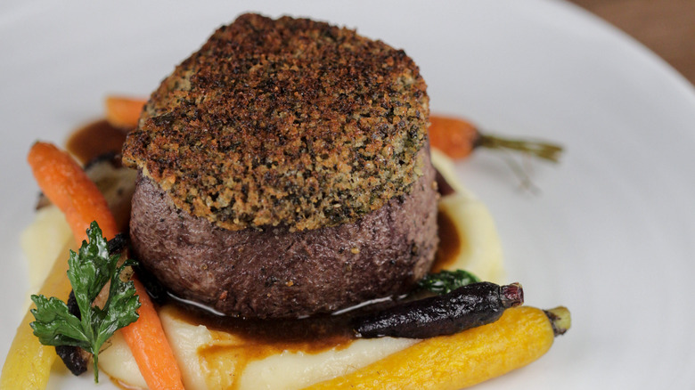 Filet of beef topped with a crunchy crust served with vegetables