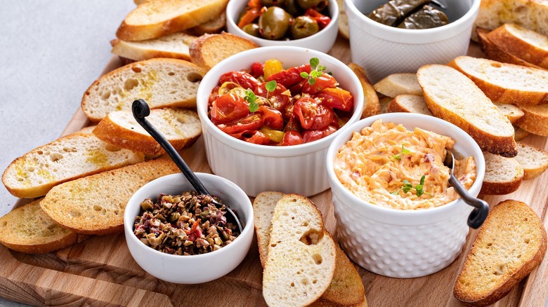 Plain crostinis next to bowls of condiments