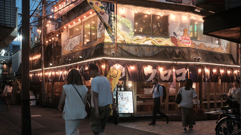 People walking by restaurant in Tokyo