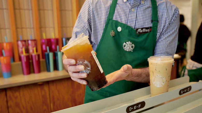 Starbucks worker holding a drink