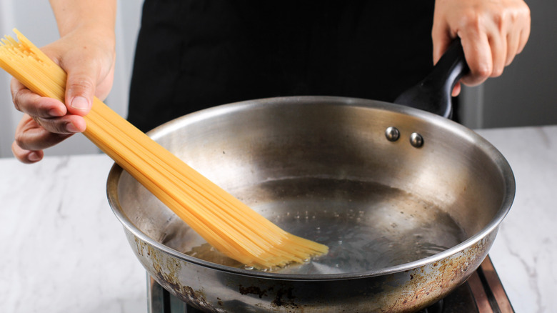 Cooking spaghetti in pan of water