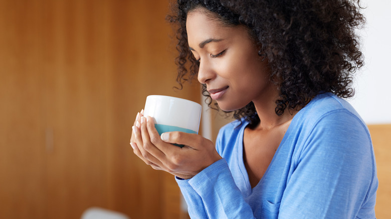 Person cradles a mug in cupped hands, enjoying its warmth