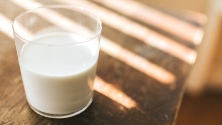 milk in a glass on wooden table