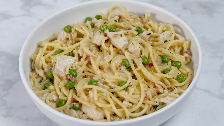 bowl of american-style carbonara with chicken and peas