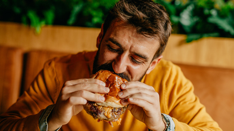 Person eating burger with hands