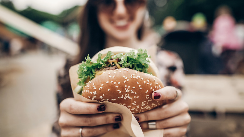 woman holding burger upside down