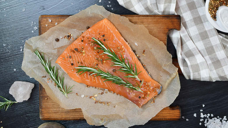 Raw salmon filet seasoned with spices and fresh rosemary