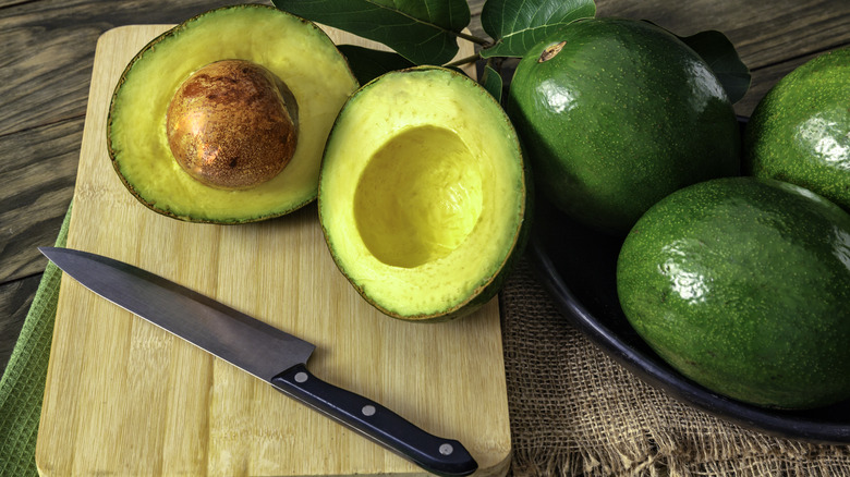 Avocados on a cutting board with knife