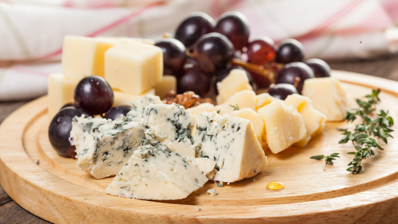 cheese and grapes on a wood board