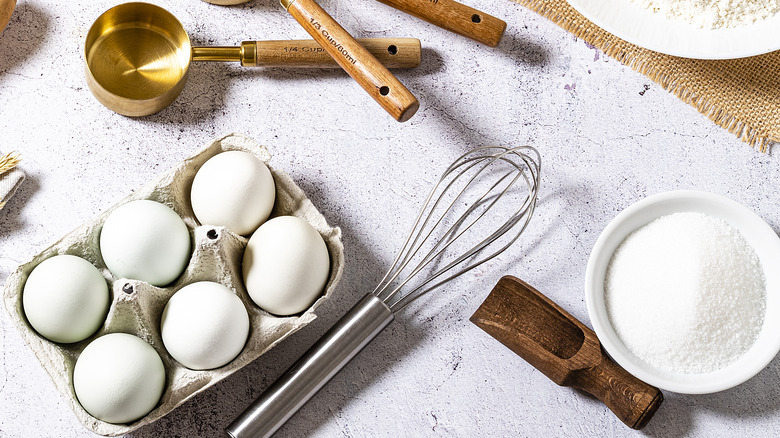 Eggs with sugar and baking tools