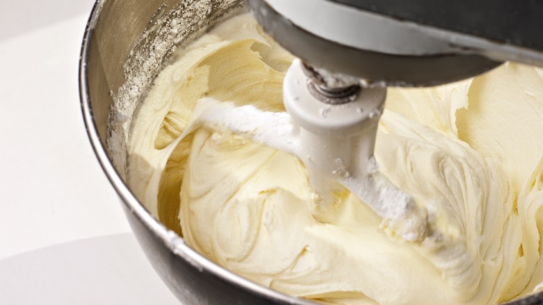 Frosting being whipped in a stand mixer 