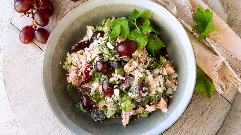 A bowl of tuna salad with grapes, served over mixed greens.