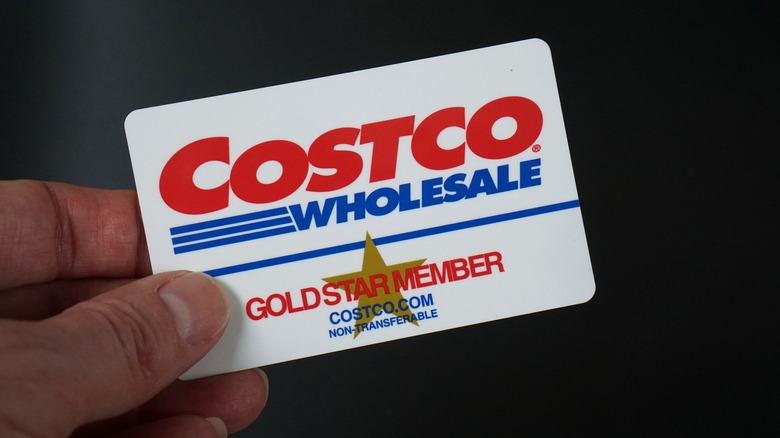 Hand holding Costco gold star member card