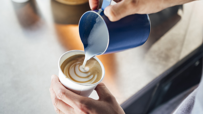 Barista pouring steamed milk