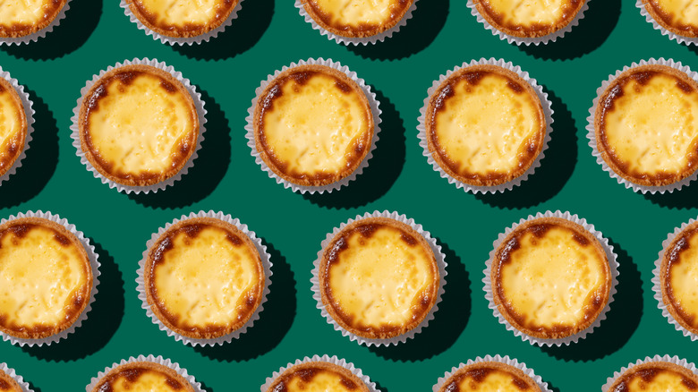 rows of egg custard tarts on green background