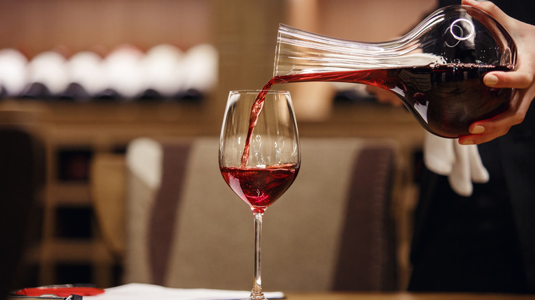 red wine being poured from a decanter into a glass