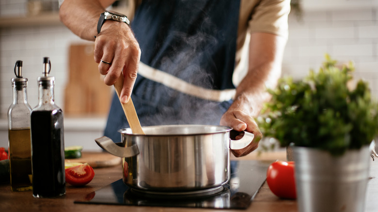 man stirring pot