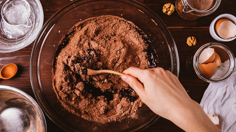 Person mixing cocoa powder in a bowl