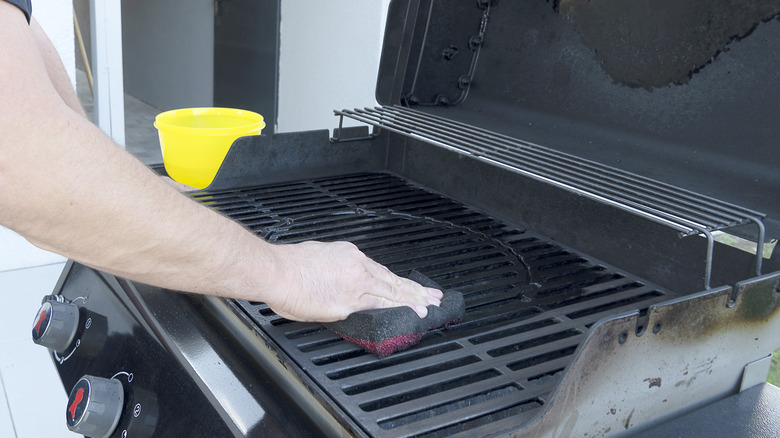 Man cleaning an outdoor grill