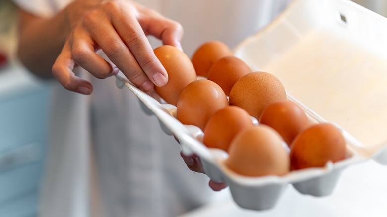 person selecting eggs out of a carton