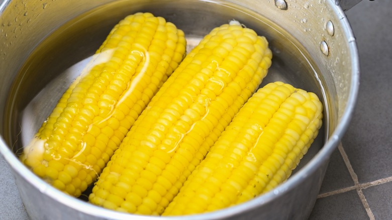 Corn on the cob in pot of boiling water