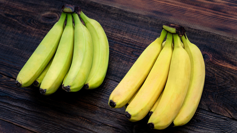 under ripe and ripened bananas on a wooden table