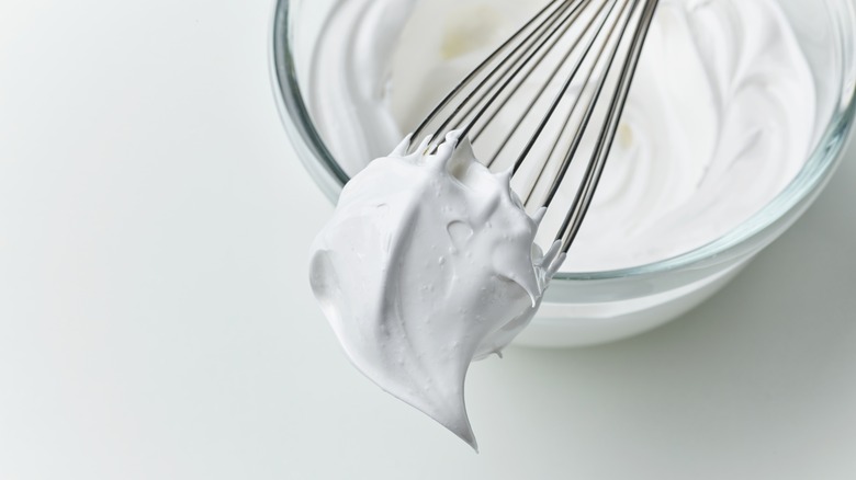 whipped egg whites on whisk and in bowl