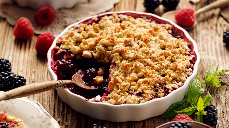 Wooden spoon serving fruit crumble