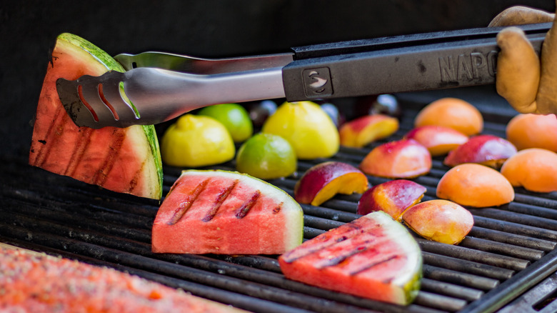 Watermelon, peaches, lemons and limes on a grill