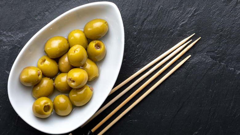 Olives in pretty bowl with skewers on side