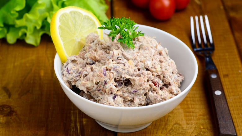 Tuna salad in a bowl with a lemon slice and garnish