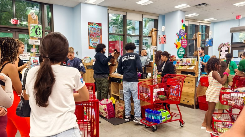 Trader Joe's customers stand in line while employees assist with checkout