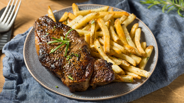 Steak and fries on a plate.