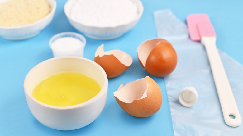 Bowl of egg whites next to egg shells