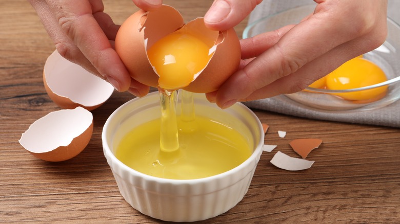 hands separating egg yolks from whites