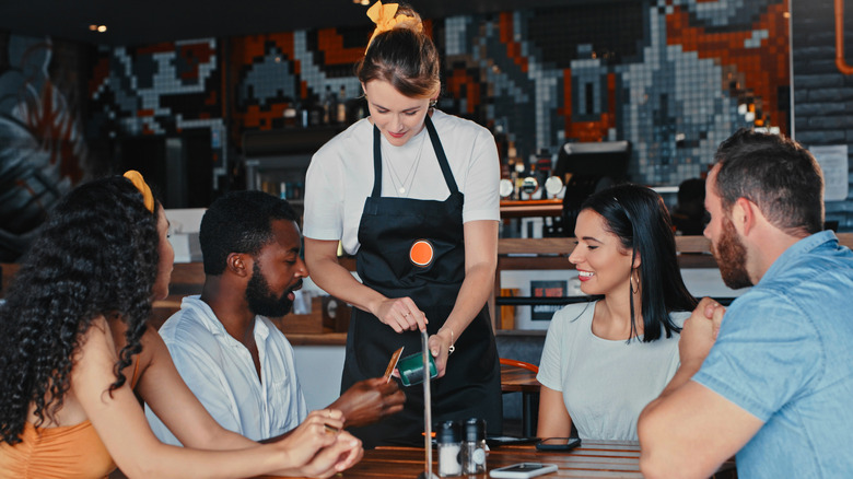 friends at restaurant receiving check