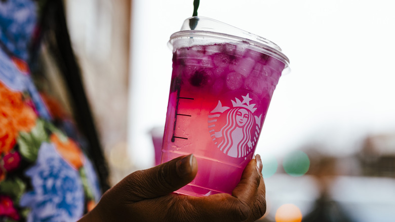 Woman holding Starbucks tea beverage