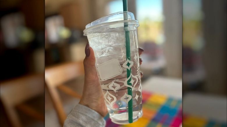 Hand holding Starbucks ice water