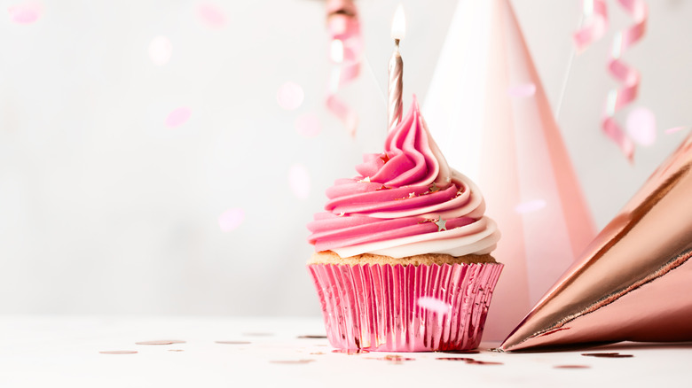 Pink frosted cupcake with single candle