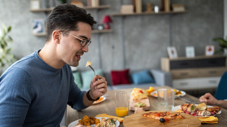 person eating fork in left hand