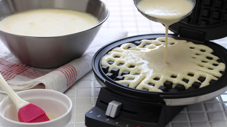 waffle batter pouring on waffle press