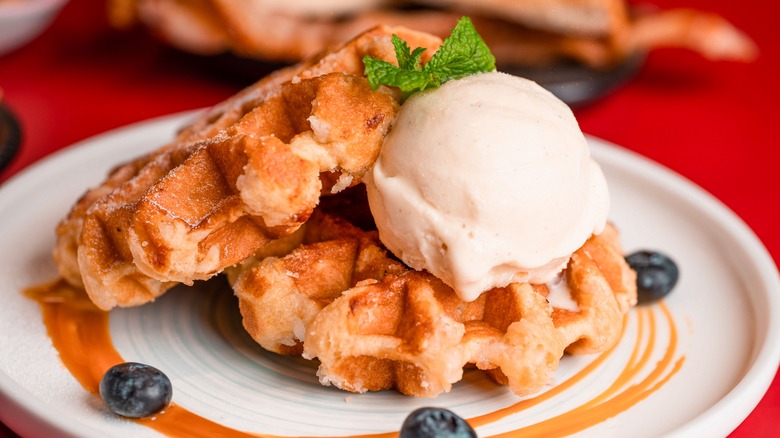 Fluffy waffles with ice cream, blueberries, and mint