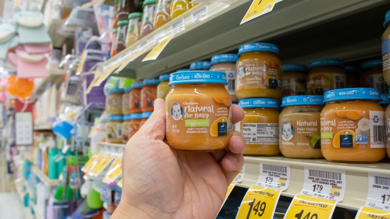 Hand holding a jar of Gerber at a supermarket