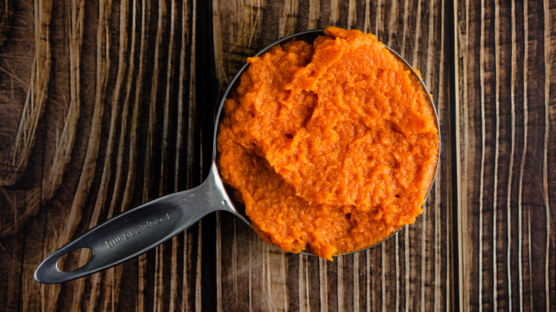 canned pumpkin in measuring cup